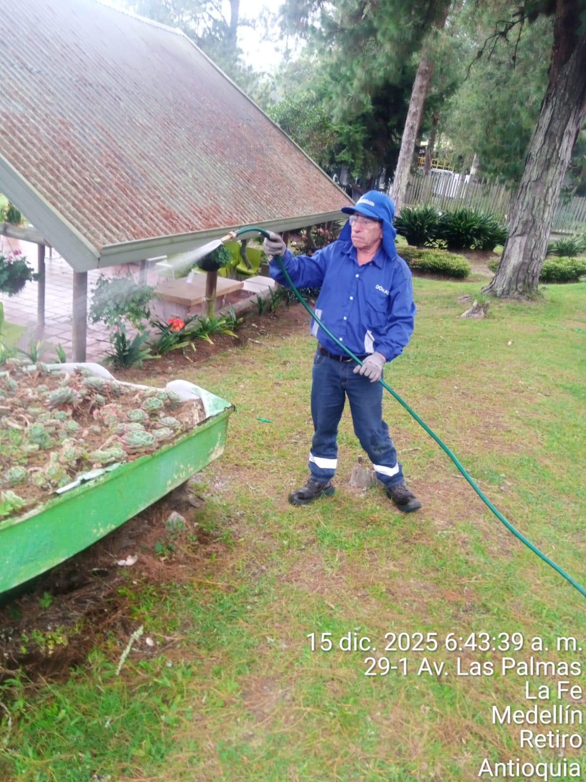 Operario Don Aseo realizando riego en jardines — Medellín, Antioquia